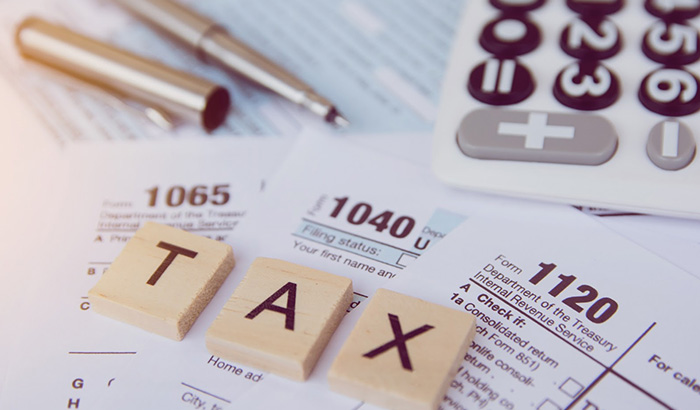 A Deskwi Tha Calculator And Taxes,representing Tax Season And Providing Helpful Tips